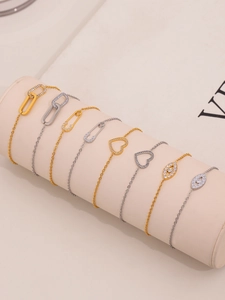 Detail of diverse gold and silver necklaces with safety pin and evil eye pendants