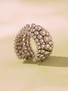 Detailed side view of multi-layer silver beaded ring with polished metallic finish