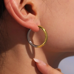 Orecchini a cerchio bicolore oro e argento in acciaio lucido indossati da una modella