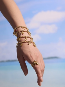 Detailed view of gold bamboo beads bracelet with starfish, heart and turtle charms