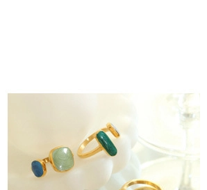 Close-up of golden adjustable rings featuring colorful square and round gemstones