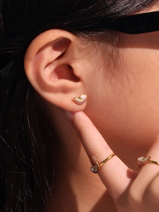 Close-up of rainbow cloud earrings and ring set on model with natural sunlight