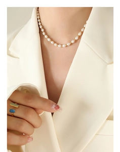 Detailed shot of baroque freshwater pearl necklace with gold beads on a model