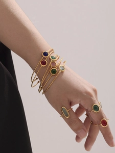 Details goldener Armreifen und Ringe mit bunten tschechischen Gläsern und Retro-Textur