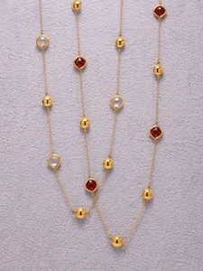 Detail van 18k vergulde ketting met rode en heldere gefacetteerde glazen stenen