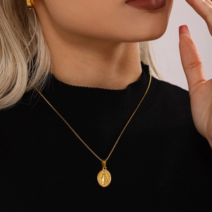 Golden Virgin Mary oval pendant necklace with box chain on elegant black turtleneck model