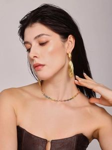 Close-up of geometric water drop earrings in 18k gold plating worn by a fashion model