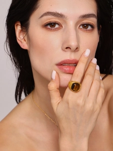 Detail of 18K gold stainless steel ring with brown tiger eye stone on model hand