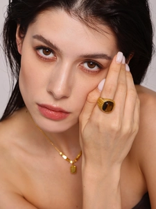Close-up of golden tiger eye stone ring and necklace with vintage woven texture