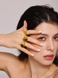 Macro detail of vintage 18K gold plated tiger eye stone rings with textured bands