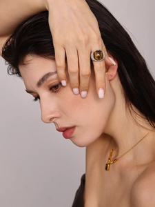 Macro shot of silver textured ring with square cabochon tiger eye stone on model