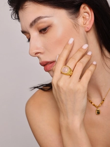 Close-up of a vintage 18K gold-plated ring with a square pink stone on a female model