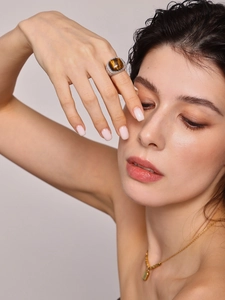 Detailed close-up of tiger eye ring with woven texture and rectangle stone necklace