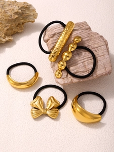 Detailed close-up of five-piece gold metal hair ties with various geometric shapes