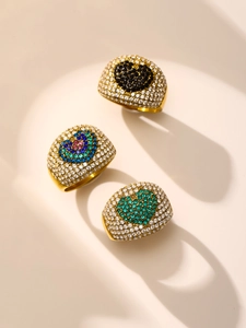 Gros plan de bagues plaquées or 18 carats avec zircons 5A et détails de cœurs colorés pavés