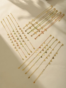 Détail d'un ensemble de bijoux coeur dorés avec strass colorés et perles fines