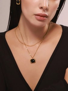 Nahaufnahme von Vintage-Goldhalskette mit schwarzem Achat-Anhänger und passenden Ohrringen