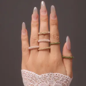 Détail de bagues empilées en acier titane avec perles et zircones vertes sur une main
