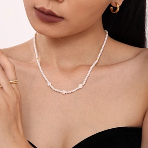 Collier ras du cou en perles avec marguerites blanches porté par un mannequin