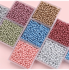 Macro shot of 4mm assorted round glass pearl beads in a transparent plastic organizer box