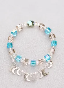 Macro detail of multi-color crystal beads with silver crescent moon and pearl charms