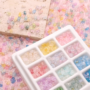 Mix of 4x6mm acrylic peanut beads with gold foil in a white organizer tray for DIY jewelry
