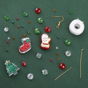 Kit de bijoux de Noël DIY avec perles et breloques festives sur fond vert foncé