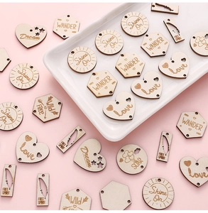 Detailed view of DIY laser-engraved wooden pendants with inspirational text and shapes