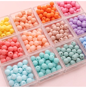 Macro shot of colorful matte acrylic beads organized in clear boxes for DIY crafts