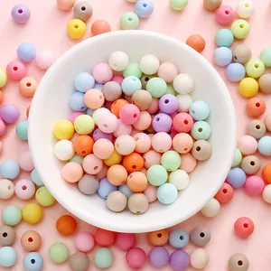 Close-up of matte macaron acrylic beads in a white bowl for DIY jewelry making