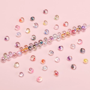 4mm bunte AB-beschichtete Glasperlen für DIY-Schmuck auf rosa Hintergrund präsentiert