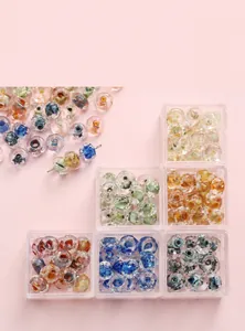 Macro detail of 12x7mm colored ripple glass beads in transparent acrylic storage boxes