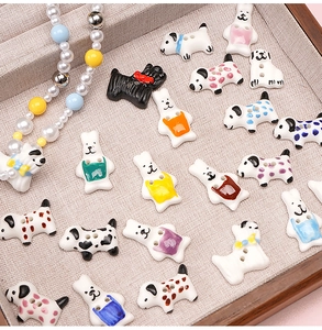 Macro shot of assorted colorful dog-shaped ceramic beads and charms on a display tray