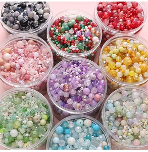 Nahaufnahme von DIY Glasperlen-Sets in neun farbenfrohen Kunststoffdosen für Schmuck