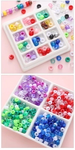 Detailed close-up of colorful acrylic barrel beads in a white 12-slot storage box