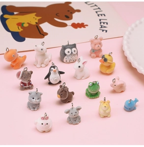 Flat lay of fourteen cute flocked animal pendants with metal rings for DIY jewelry making