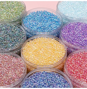 Macro shot of colorful glass seed beads in transparent jars for DIY jewelry making crafts