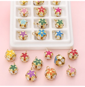 Detailed view of colorful cloisonné hollow bells with floral patterns for DIY jewelry