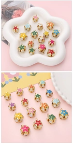 Macro shot of colorful hollow enamel bell pendants with gold floral cut-out design