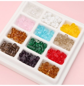 Flat round glass beads in 12 colors sorted in a white grid tray for DIY jewelry making