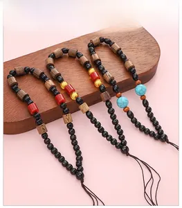 Close-up of handmade braided cords with dark wood beads and vibrant gemstone accents