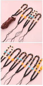 Macro detail of hand-woven cord with turquoise beads and a carved wooden Pixiu pendant