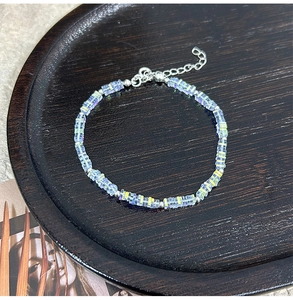 Detail of a square crystal glass bead bracelet with iridescent blue purple glow