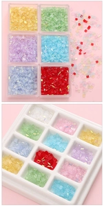 Macro shot of iridescent 1x3mm crystal cube beads in multi-colored storage tray