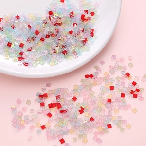 Colorful 1x3mm square glass crystal beads in a white ceramic dish for DIY jewelry making