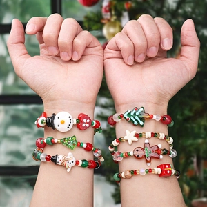 Close-up of seven festive Christmas charm bracelets with snowman and tree pendants