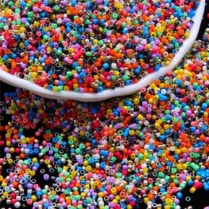 Makroaufnahme von 2mm bunten Glasperlen für DIY-Schmuck und Bastelarbeiten in weißer Schale