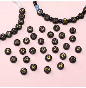 Détail de perles en acrylique noir plat avec lettres dorées pour bijoux DIY