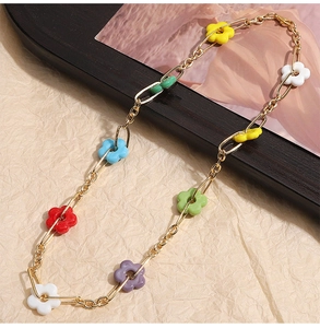 Detailed view of a gold chain necklace featuring vibrant multi-colored glass floral charms