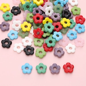 Colorful floral resin glass beads for DIY jewelry making displayed on pink background